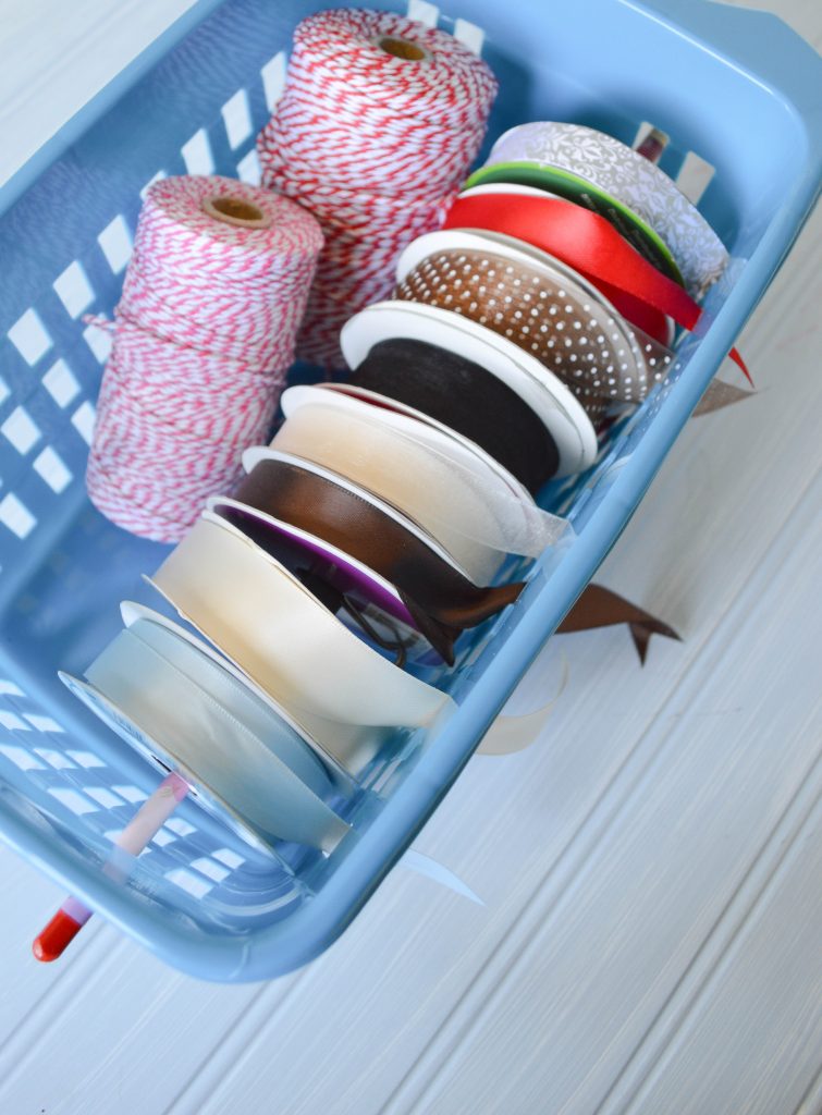 Take a dollar store plastic bin and turn it into a organized ribbon dispenser 