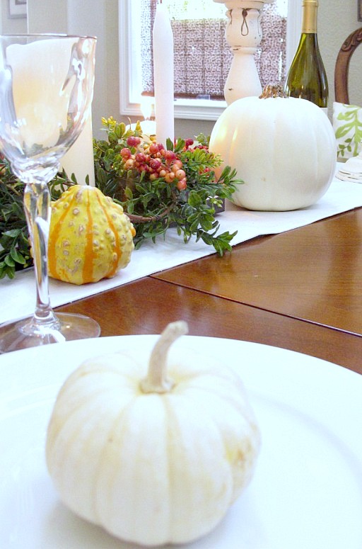 line up mini pumpkins down the center of the table with candles, flowers and gourds for a beautiful thanksgiving display