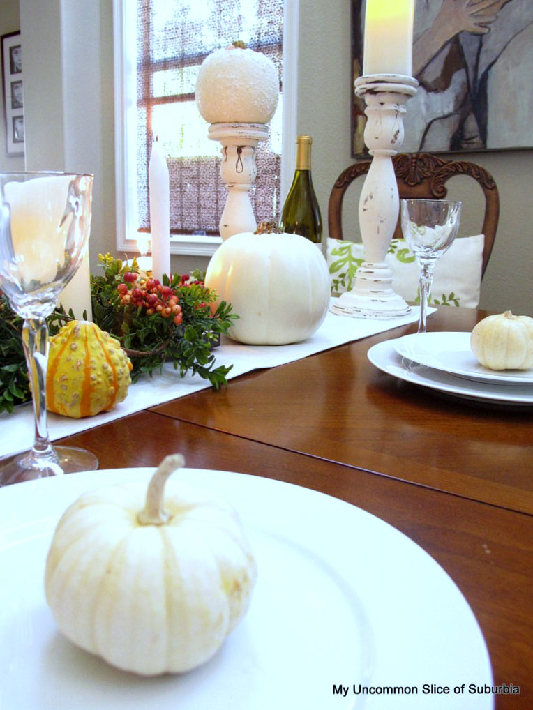 line up mini pumpkins down the center of the table with candles, flowers and gourds for a beautiful thanksgiving display