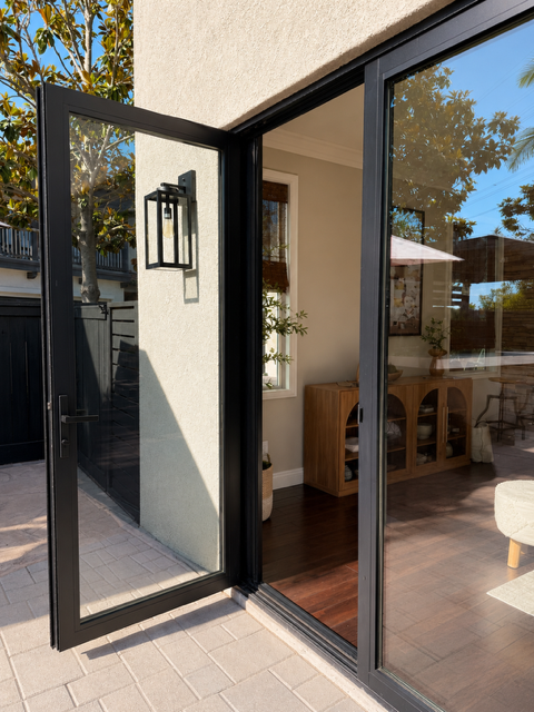 Panoramic sliding glass doors fully open to outdoor space
