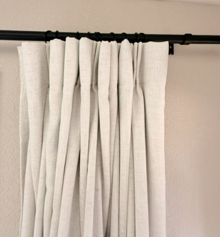 Drapes styled beside sliding glass doors with olive tree accent